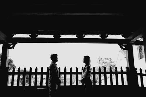 Free Positive young ethnic couple smiling and looking at each other on veranda Stock Photo