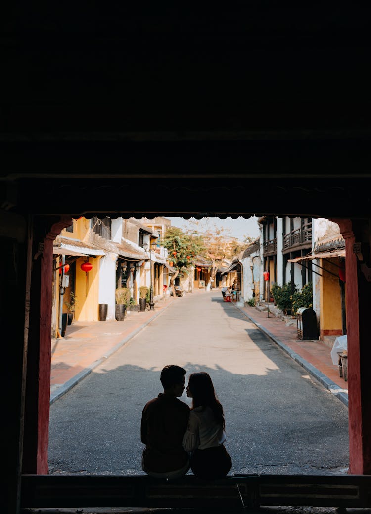 Unrecognizable Romantic Couple Hugging While Sitting On House Porch