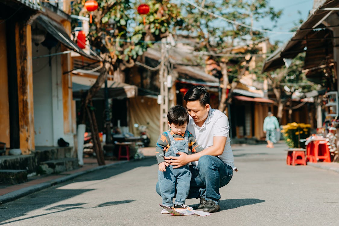 Young ethnic father with little son spending time together in town