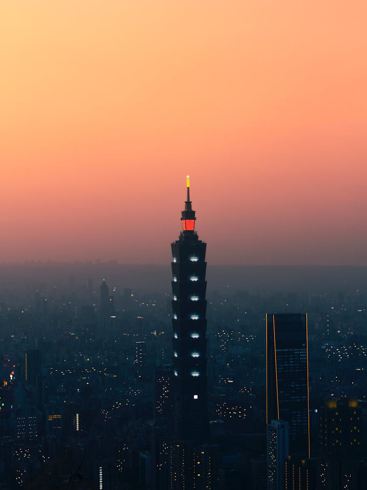 Red And Yellow Tall Tower  Under Orange Sky