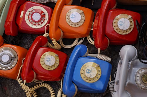 Семь разных цветных поворотных телефонов