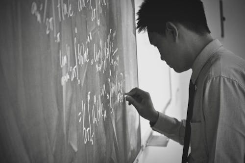 Free Man Writing on Blackboard Stock Photo