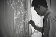 Man Writing on Blackboard