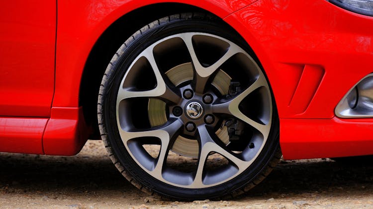 A Gray Alloy Rim On A Red Car