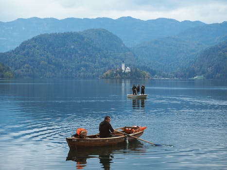 A serene autumn scene at Lake Bled, Slovenia, with boats and a church on an island.