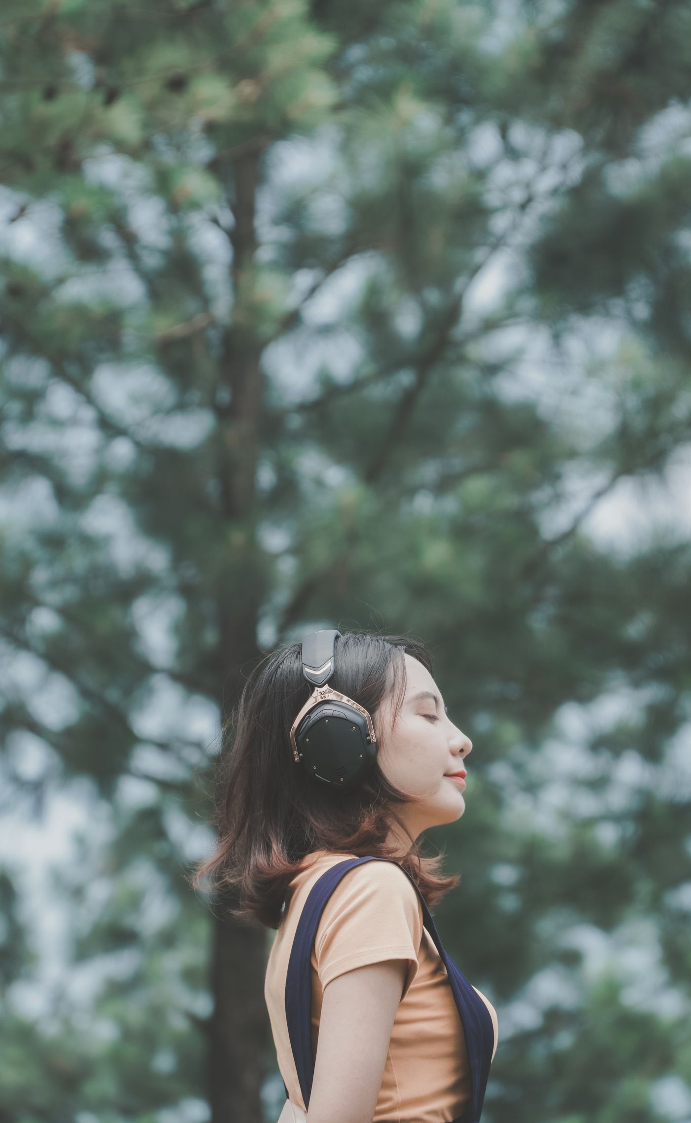 Woman with headphones in a pine forest