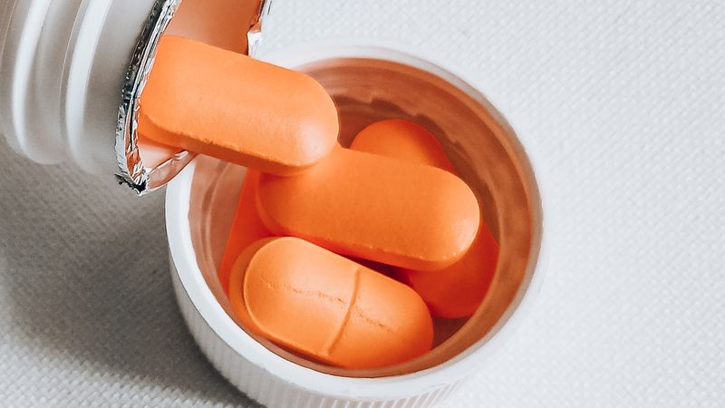 Orange antidepressant pills spilling from a white bottle, central to CBD and antidepressants safety questions