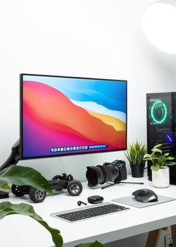 Clean and contemporary desk setup featuring a monitor, camera, and tech gadgets in a modern workspace.. pexels, clean, contem