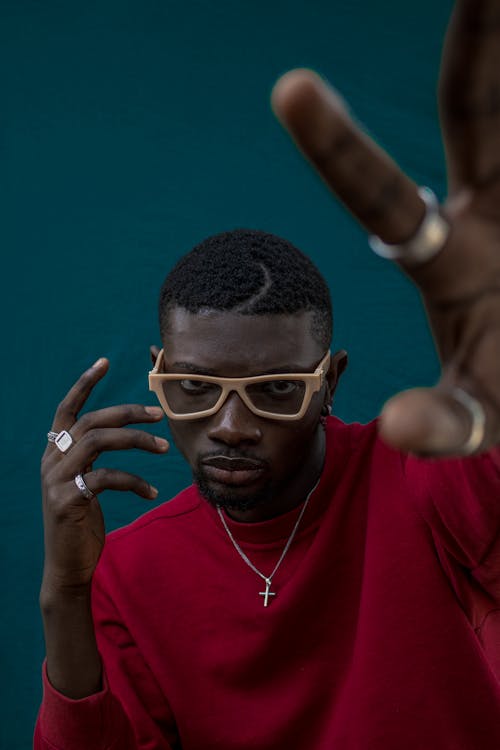 Cool black man in sunglasses raising arms