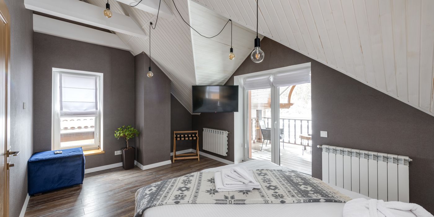Calm hotel bedroom interior with neatly made bed and bedside lamp