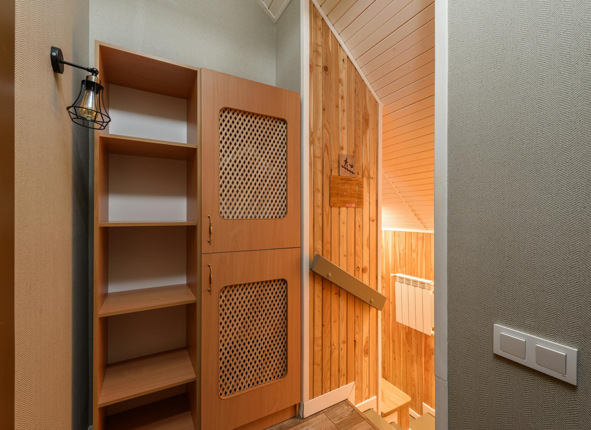 Warm and inviting wooden interior featuring rustic cabinet and shelved storage with a homey ambiance.