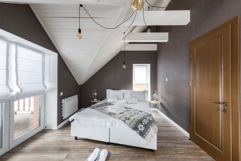 Corner room at Nāra with linen curtains drawn back from a tall window