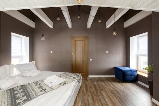 Spacious modern bedroom featuring a minimalistic aesthetic with elegant decor and warm tones.