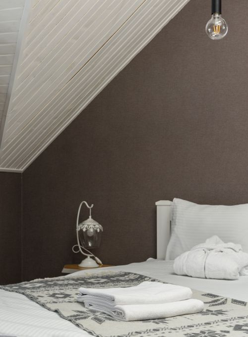 Free Elegant bedroom interior with neatly arranged bed and vintage lamp, ideal for home design inspiration. Stock Photo