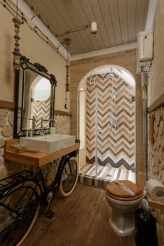 A rustic bathroom featuring unique bicycle decor and a modern shower with chevron tiles.
