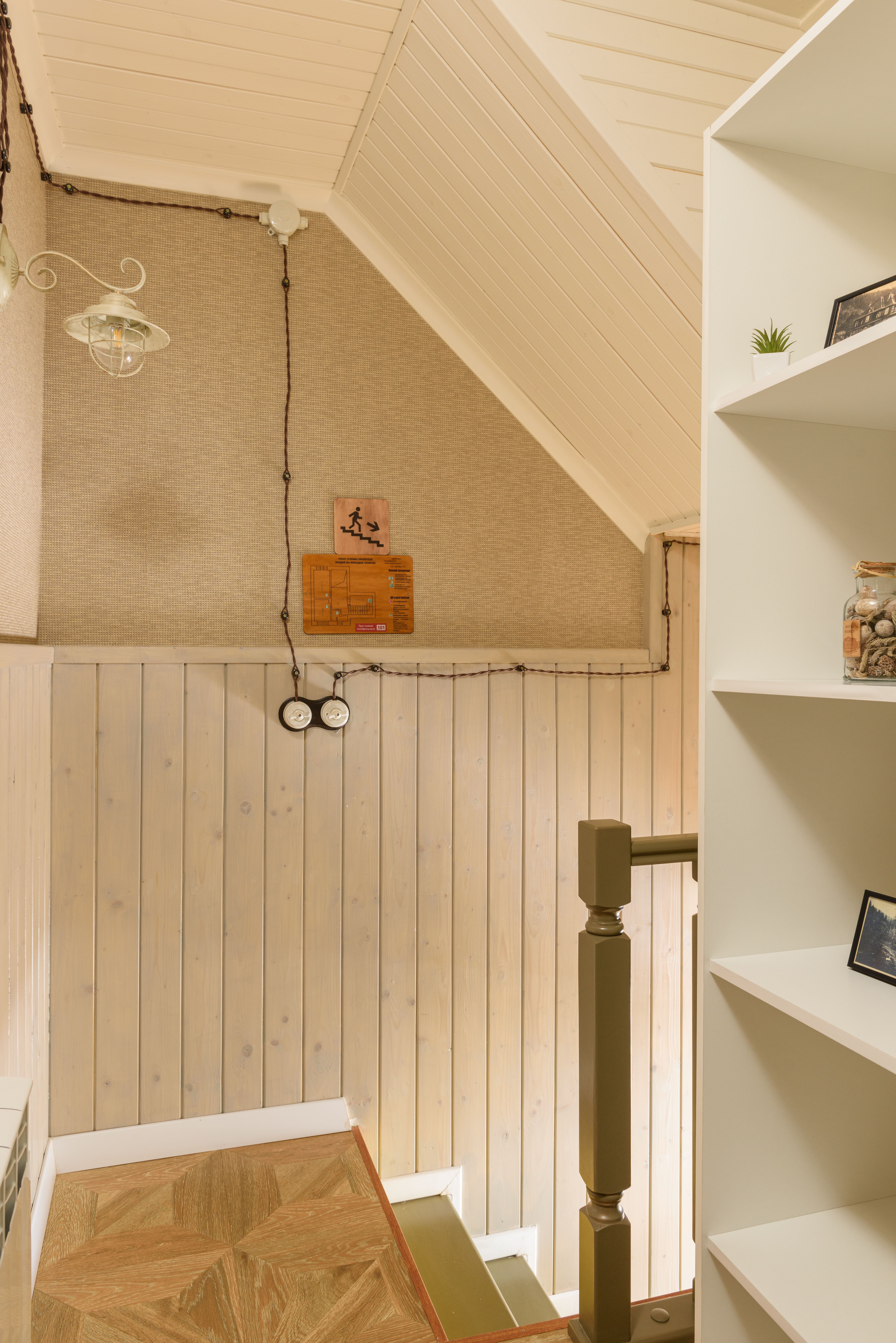 Warm and inviting interior with wooden staircase, shelves, and ambient lighting.