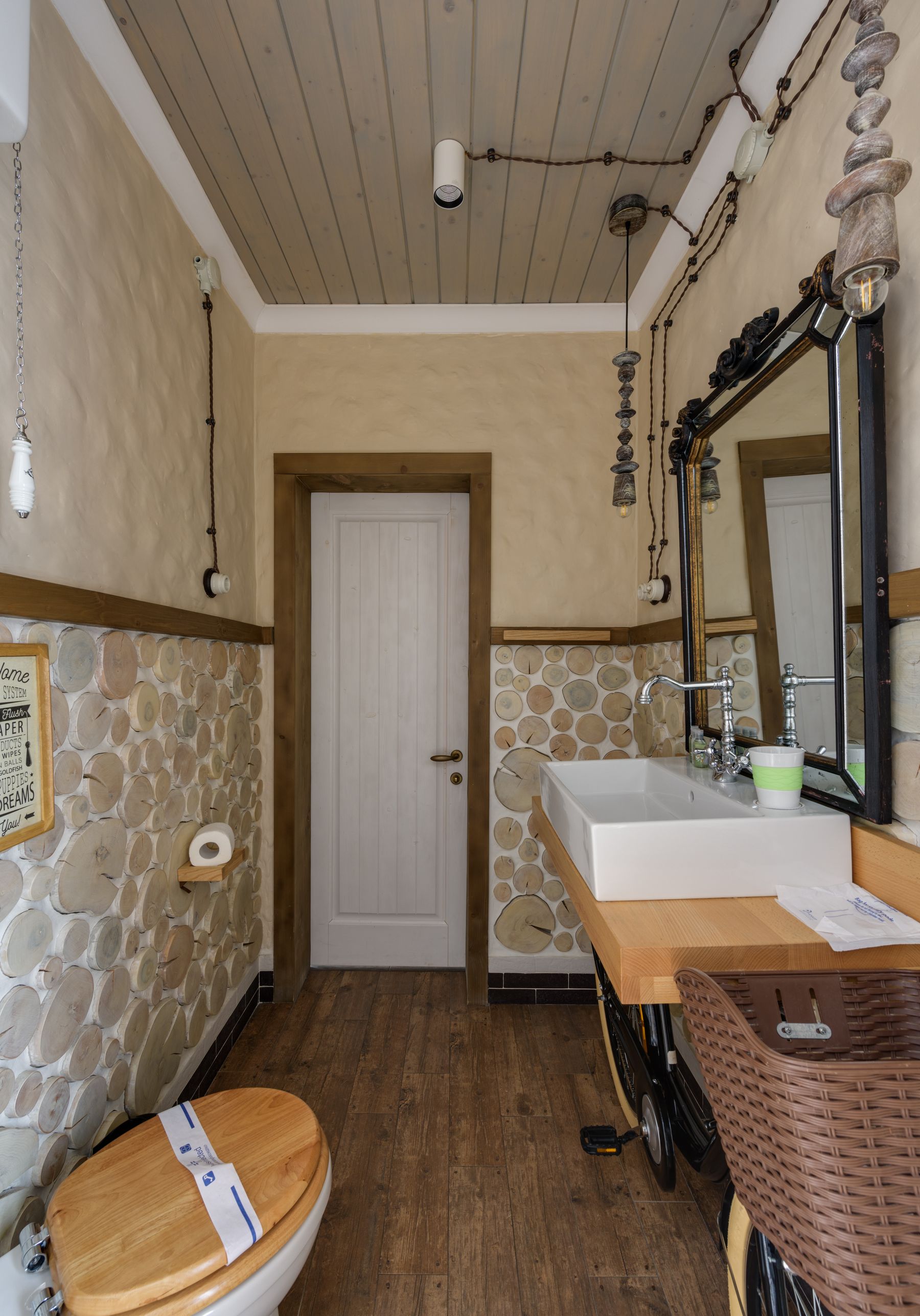 Warm bathroom with natural wood, pale surfaces and practical furniture-like fixtures