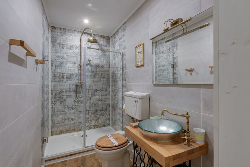 Contemporary travertine and brass bathroom in Miami