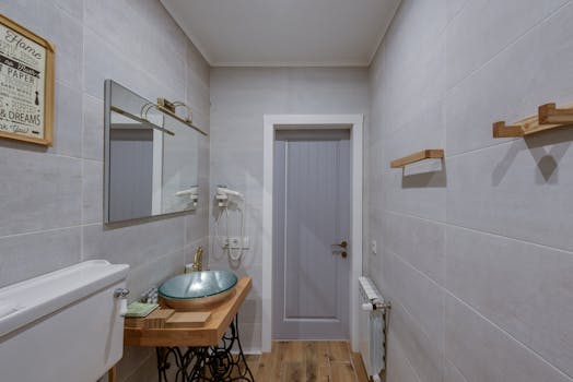 Contemporary bathroom featuring a unique wooden sink design and minimalist decor with warm tones.