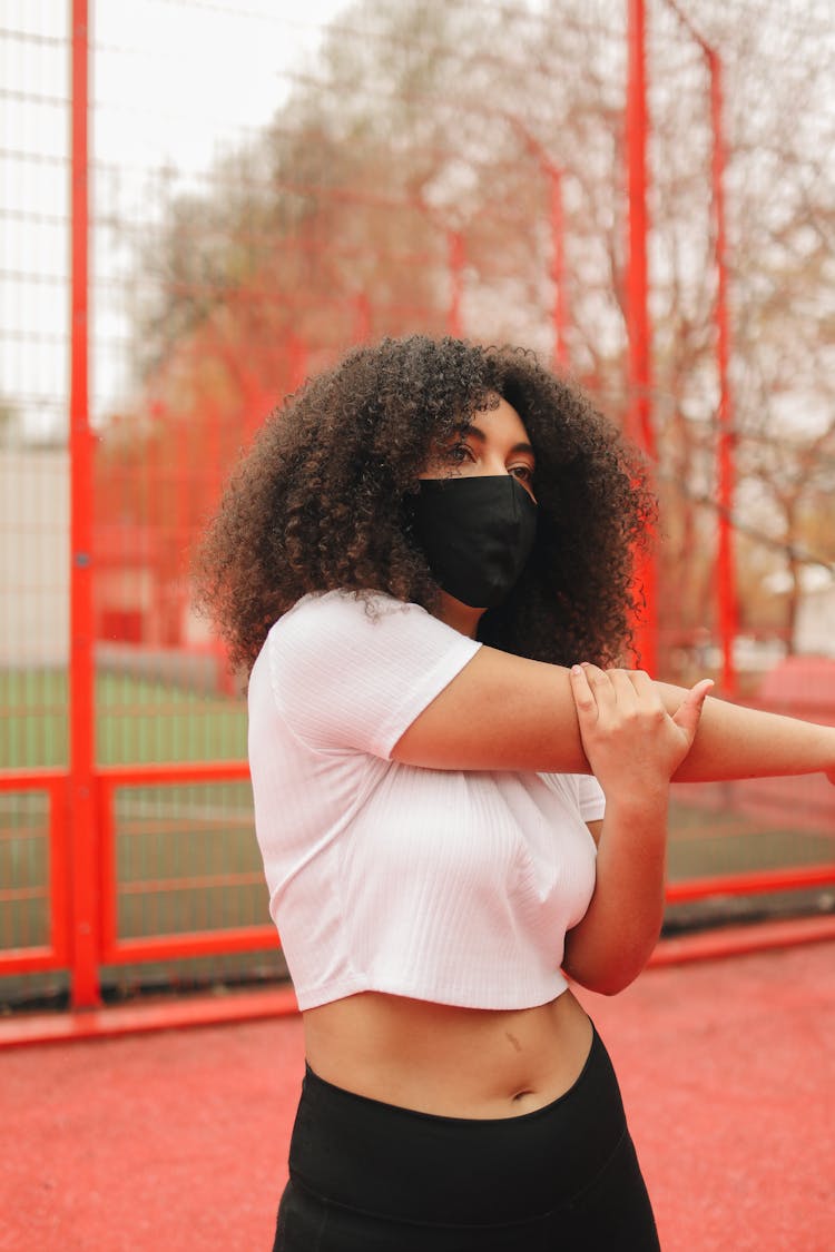 A Woman Exercising Outdoors While Wearing A Face Mask