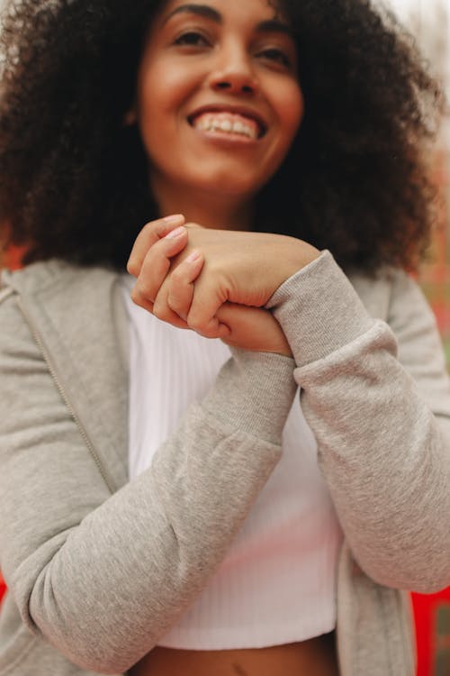 A Happy Woman Wearing a White Crop Top and a Gray Jacket