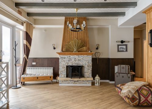 Free Charming rustic living room featuring a stone fireplace, wooden accents, and vintage decor. Stock Photo