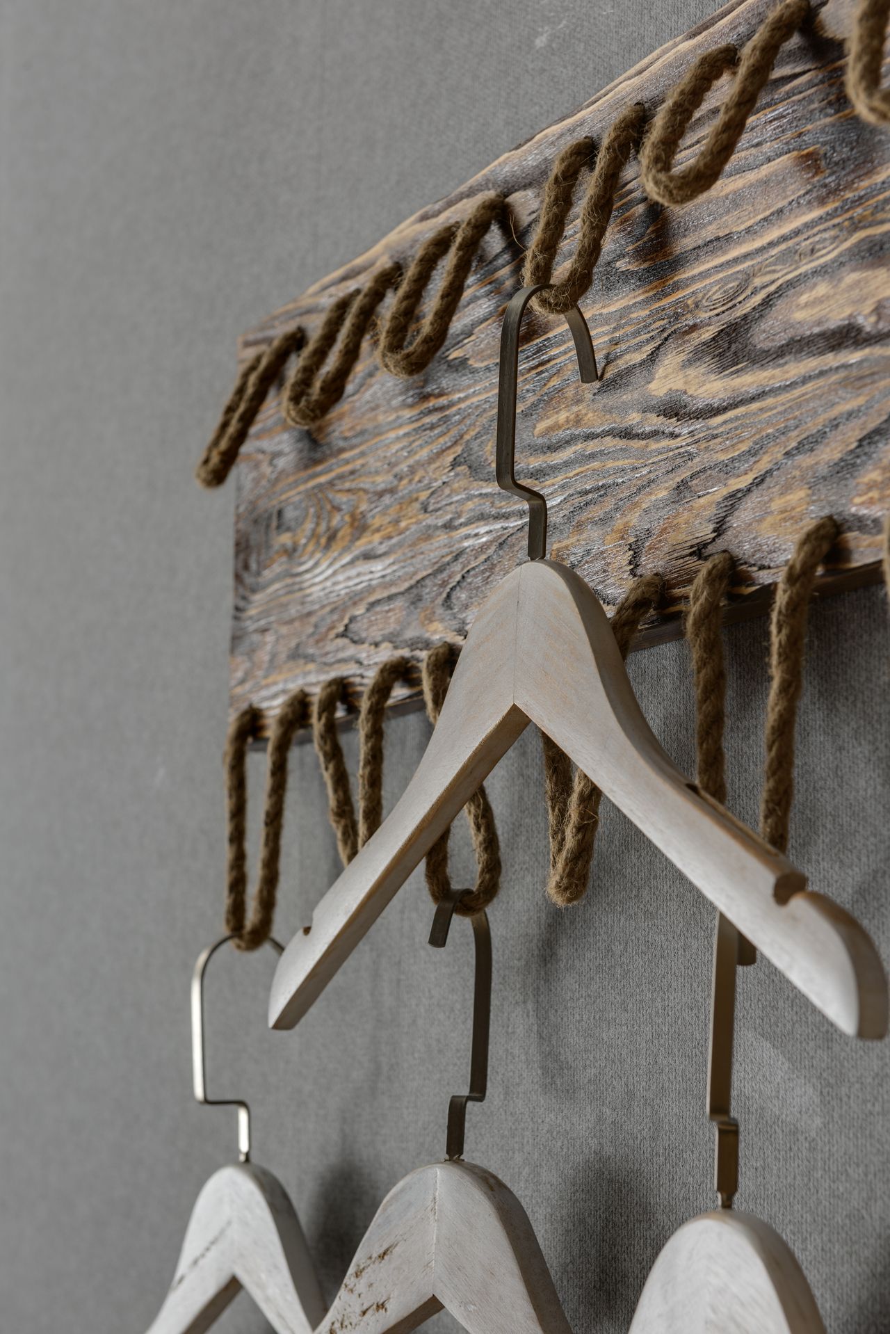 Rustic wooden coat rack with hangers in entryway Rustic wooden coat rack with hangers in entryway