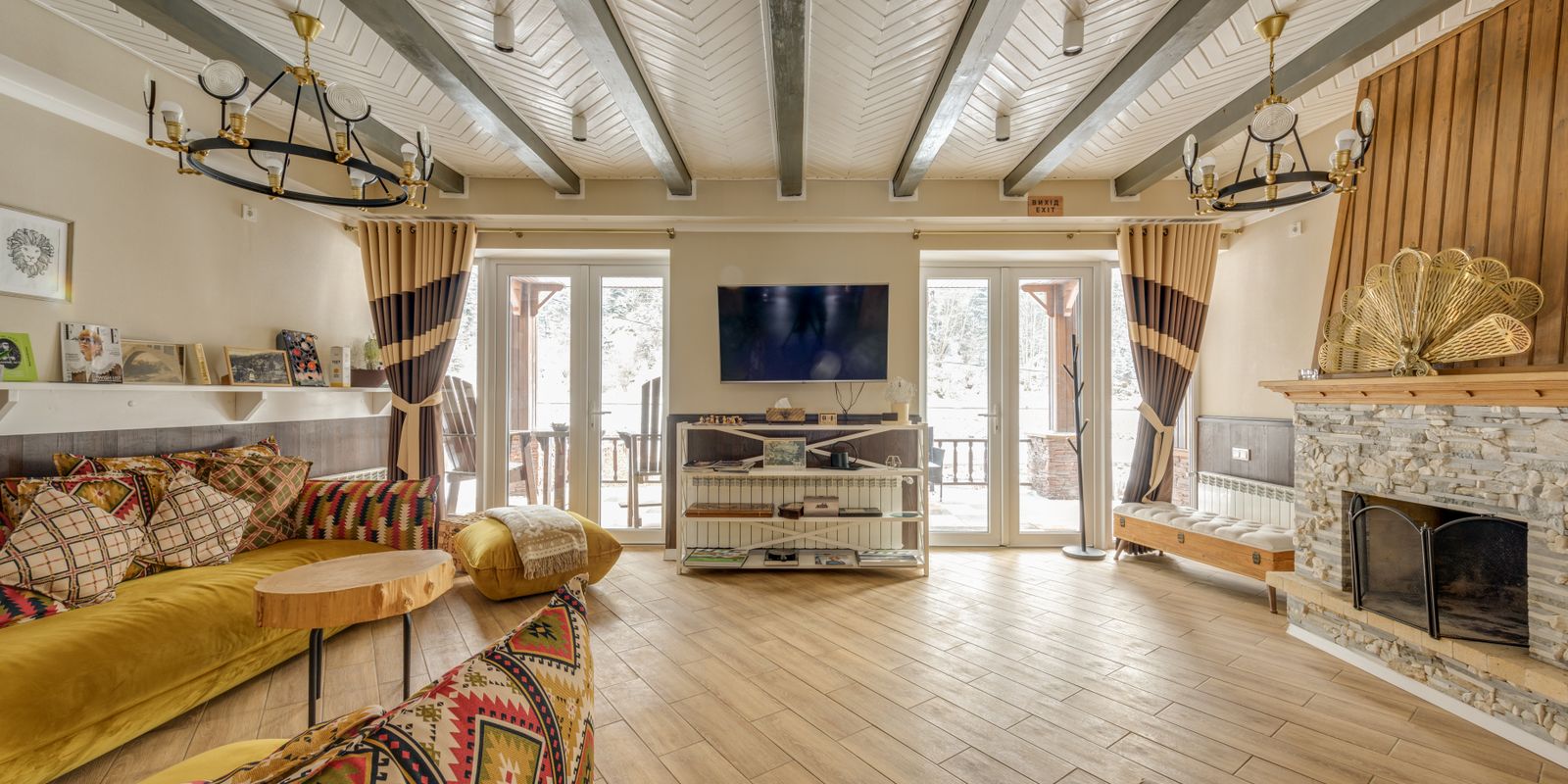 A cozy chalet interior with rustic decor and a large stone fireplace