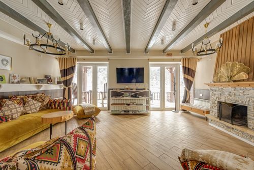 Free Inviting chalet interior with rustic decor and large stone fireplace, creating a warm atmosphere. Stock Photo