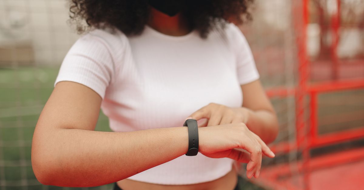 runner checking smartwatch during sunrise, data overlay on wrist