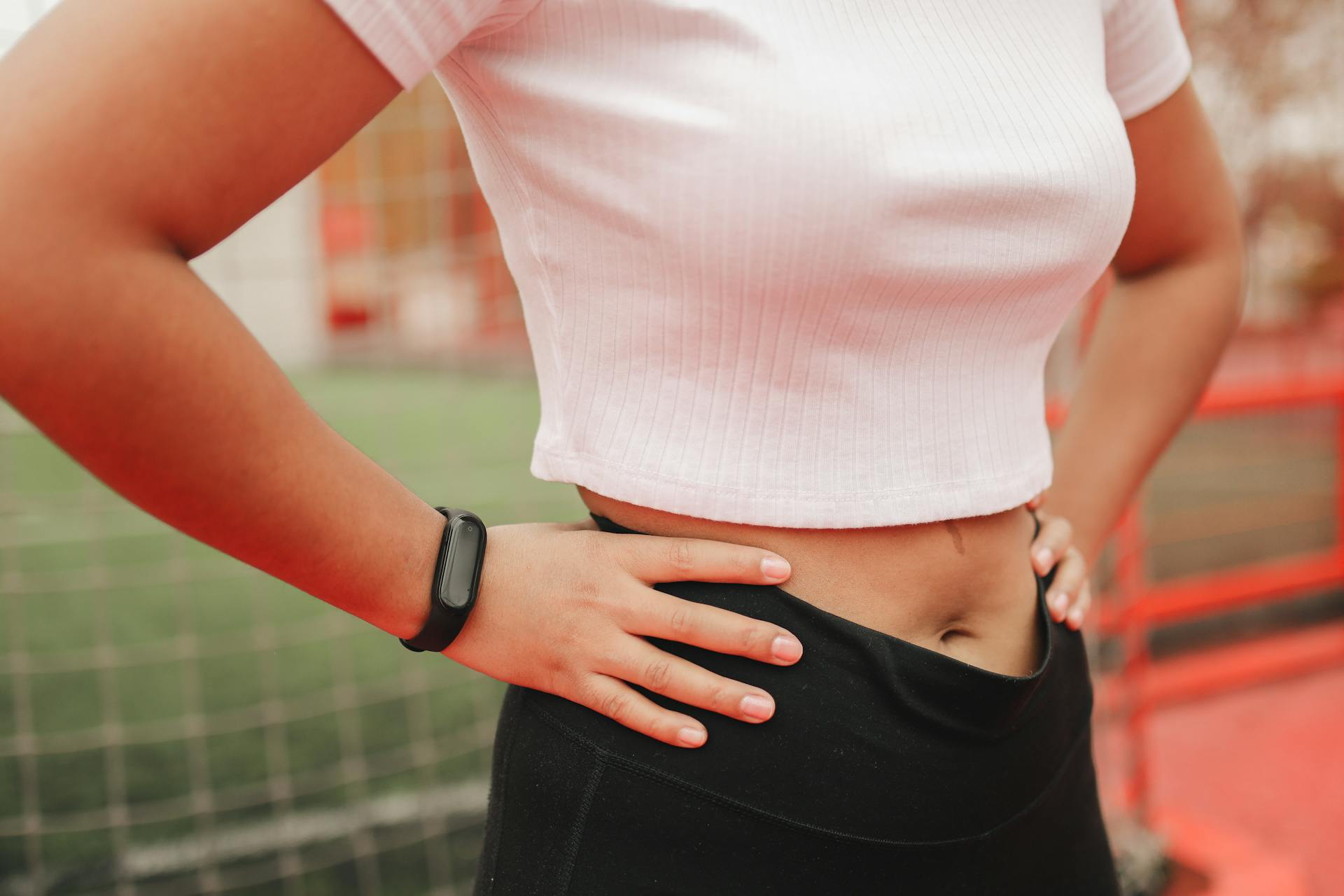 Woman in White Shirt Wearing a Fitness Tracker