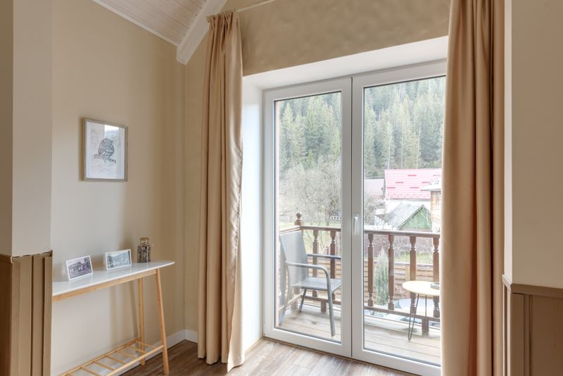 Room with balcony overlooking serene forest view