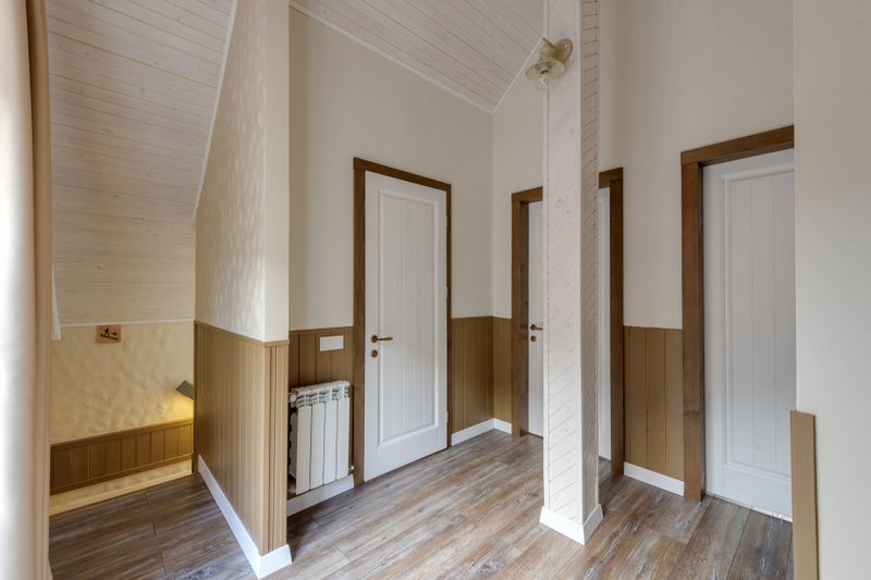 Empty hallway in a modern chalet with wooden doors and elegant design.
