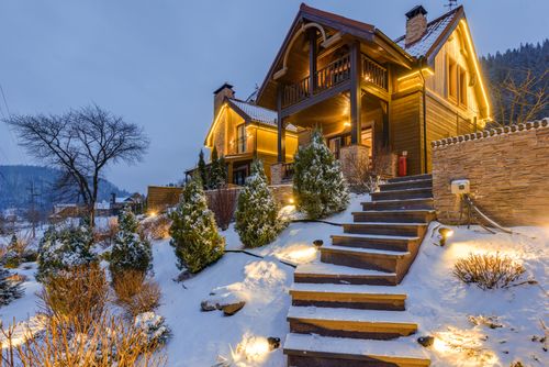 Free Cozy wooden chalet in snowy mountains, warmly illuminated during twilight. Stock Photo