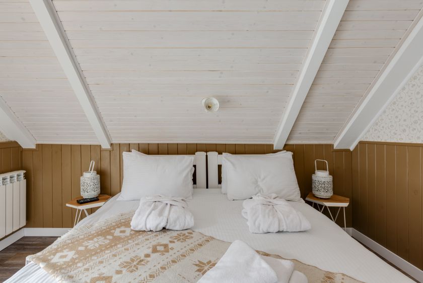 Attic double at Nāra with crisp white linen and a sloped timber ceiling