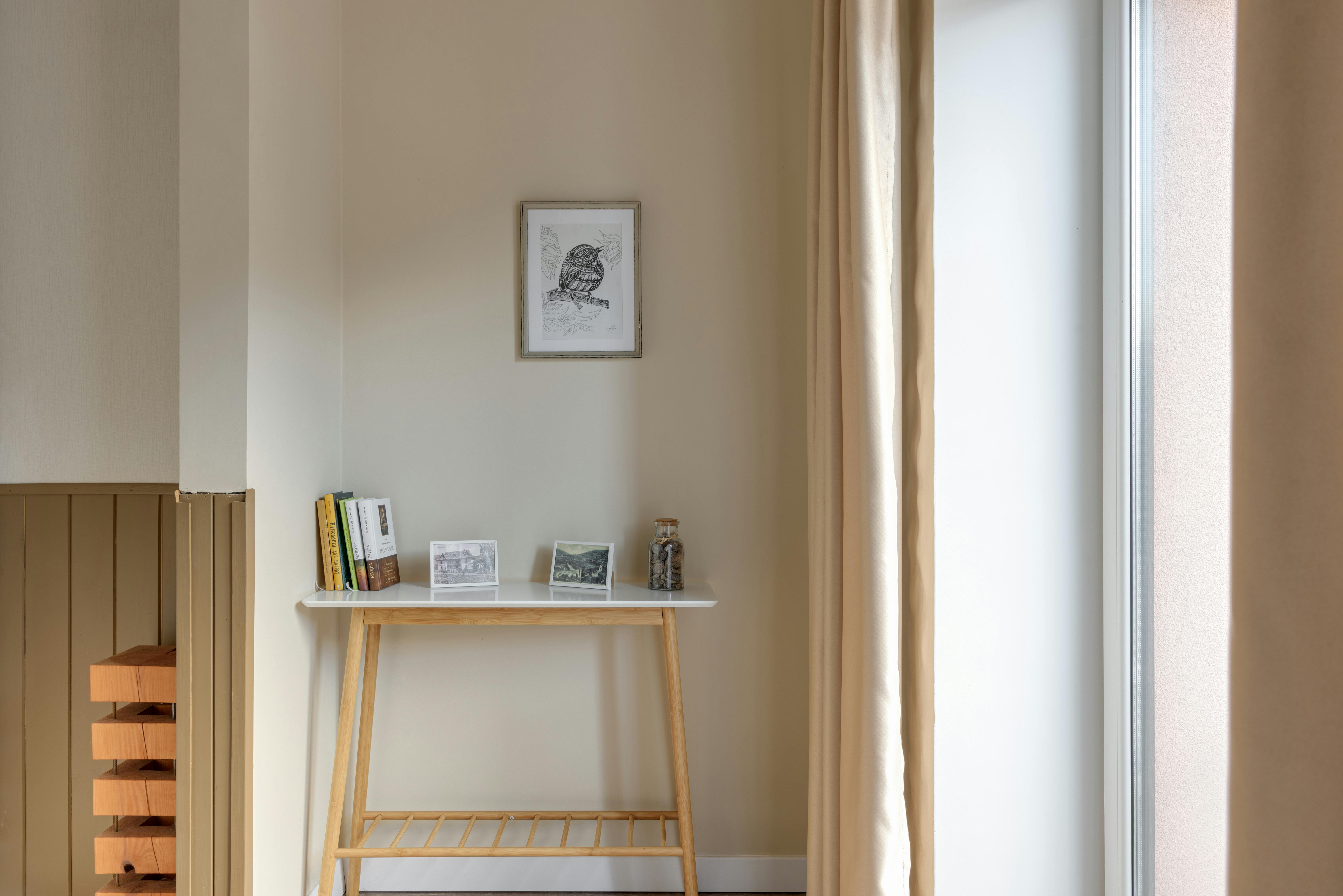 Bright small living room with light neutral paint, minimal furniture, and natural window light creating open feel