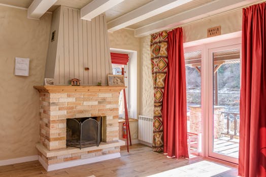 Inviting interior with a brick fireplace and red curtains, featuring elegant decor.