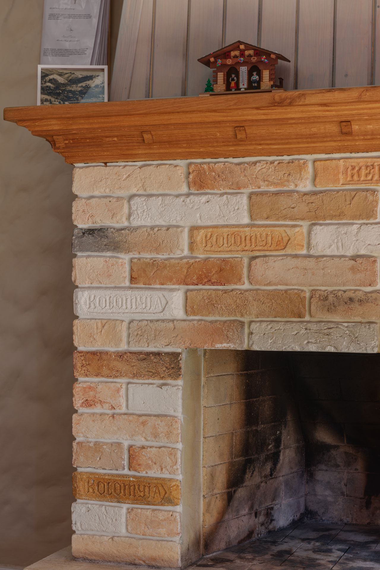 Close-up of light brick fireplace showing mortar joints and wood mantel