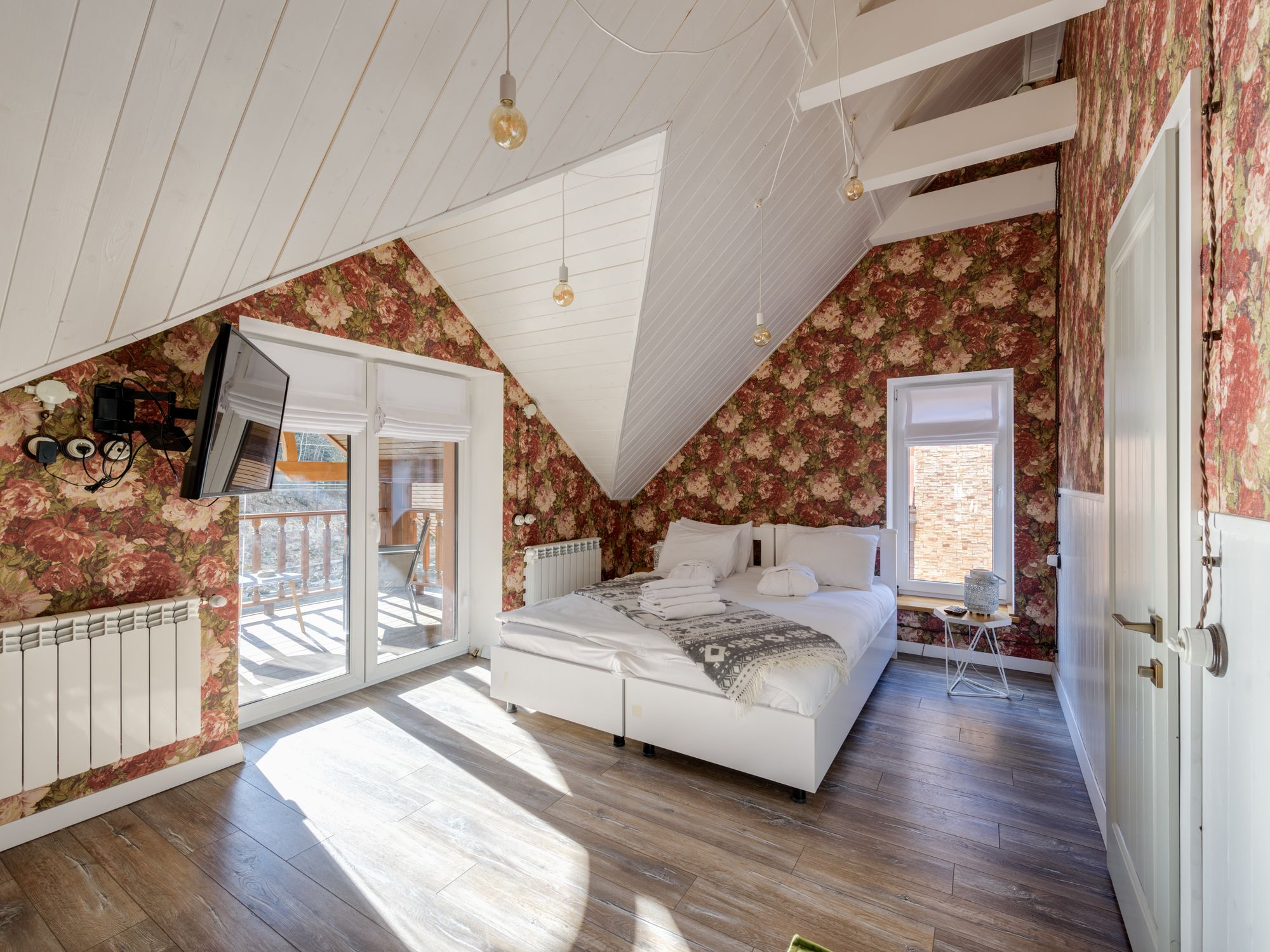 Sunlit bedroom finished with elegant floral wallpaper