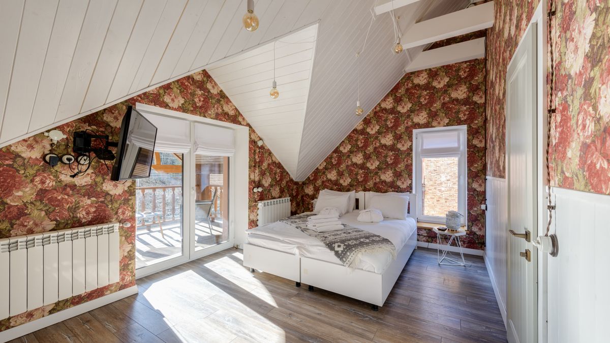 A bedroom with floral wallpaper. Buy one spare roll from the same print batch.