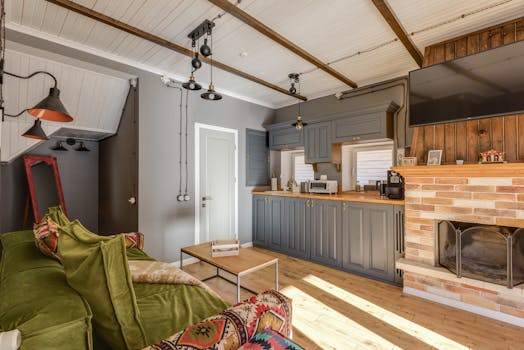 Warm and cozy living room with kitchen, featuring a fireplace and contemporary design elements.