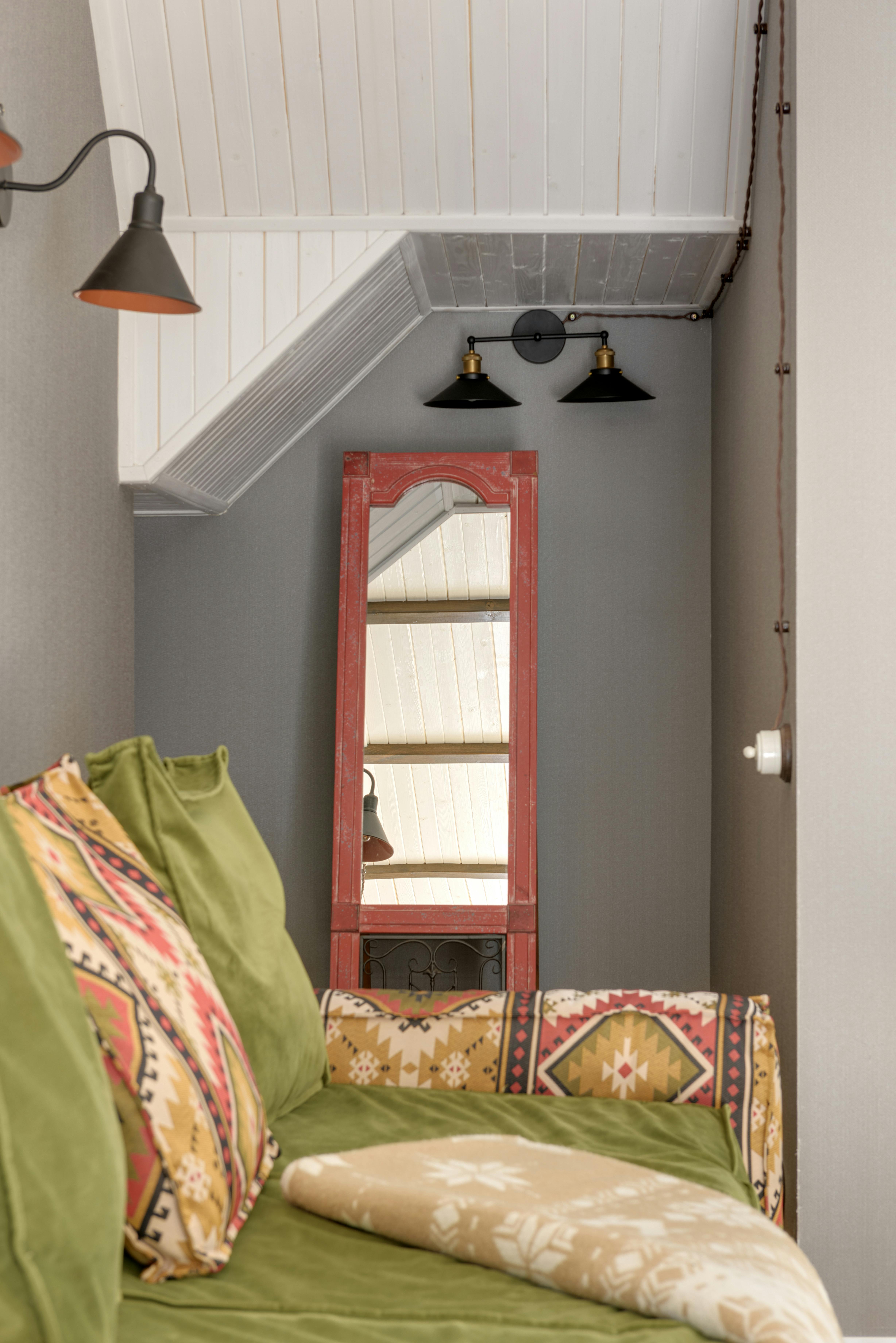 Free A snug interior space featuring a green sofa and vintage mirror, perfect for relaxation. Stock Photo