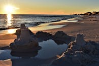 宁静的海滩上，日落时分，海浪拍打着沙堡