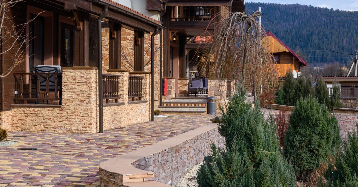 Beautiful rustic house exterior with landscaped walkway in a tranquil countryside setting.