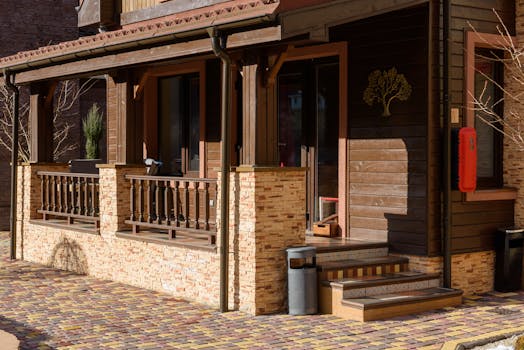 Beautiful wooden house exterior with stone accents and a cozy porch in bright daylight.