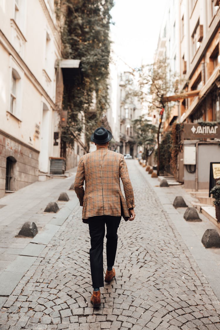 Man Walking On A Cobblestone Street In The City 