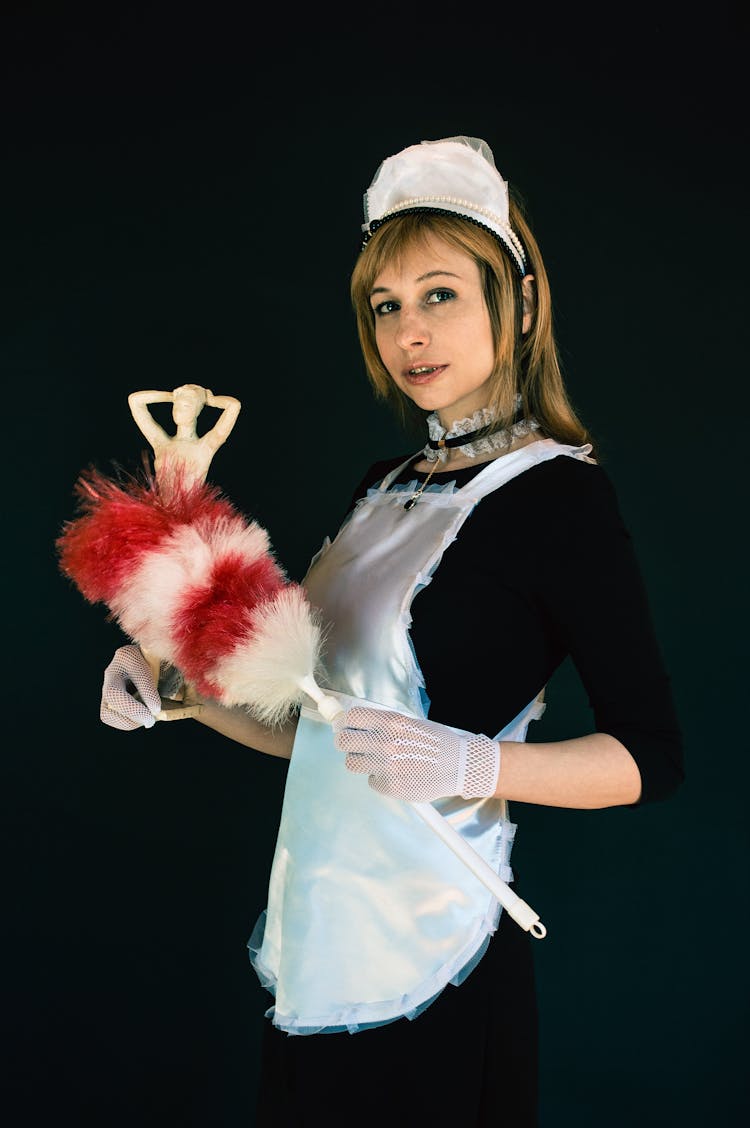 Smiling Woman In Costume Of Maid Wiping Dust From Statuette