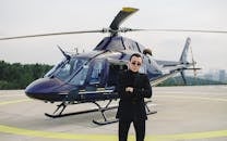 A Man Wearing a Black Outfit Standing beside a Helicopter