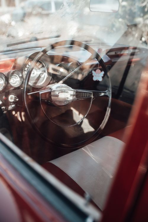 Free A detailed view of a vintage car's interior focusing on the steering wheel and dashboard. Stock Photo