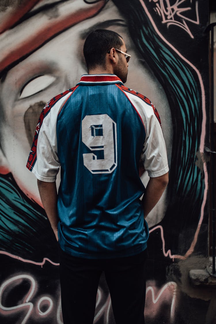 Back View Of A Man Wearing A White And Blue Jersey